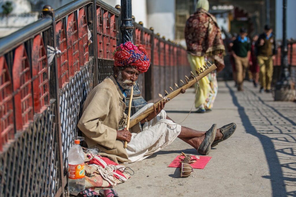 senior ethnic man playing dilruba on street